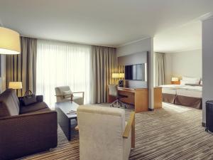 una habitación de hotel con una cama y un sofá en Mercure Düsseldorf Kaarst, en Kaarst