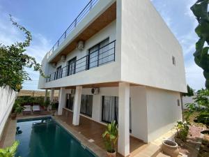 a house with a swimming pool in front of it at Villa Le Charme de Somone Piscine privée confort & proximité plage in Somone