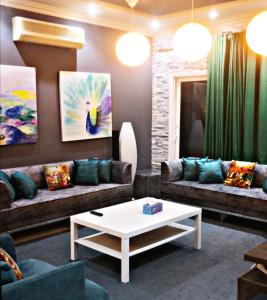 a living room with couches and a coffee table at High Residence - Spacious & Lux Apt in Muscat