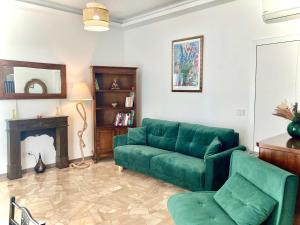 a living room with a green couch and a fireplace at Charming king studio with balcony and jacuzzi in Como