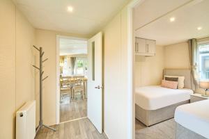 a small bedroom with a bed and a dining room at Nightingale Lodge with Hot Tub in Barmby on the Moor