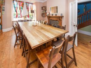 a dining room with a large wooden table and chairs at Sunnycote in Arnside