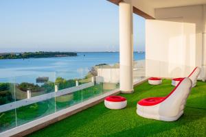 a balcony with a red bench and a view of the ocean at Sweet Apartment in Tanga