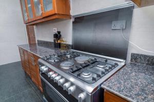 a kitchen with a stove top oven in a kitchen at Sweet Apartment in Tanga +7 photos