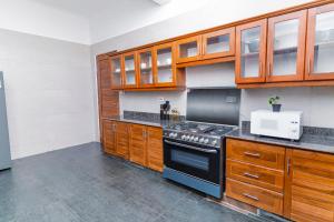 a kitchen with wooden cabinets and a stove at Sweet Apartment in Tanga