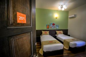 three beds in a room with a sign on the wall at Palm City Villa in Kuantan