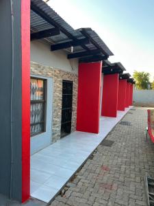 een rij rode pilaren op een gebouw bij Lake boutique hotel empire in Thohoyandou