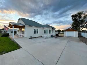 a white house with a large driveway in front of it at POEs Place in Panguitch