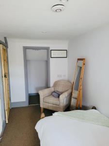 a bedroom with a couch and a chair and a bed at Above the Bear in Wiveliscombe