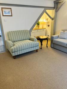 a living room with two couches and a table at Above the Bear in Wiveliscombe