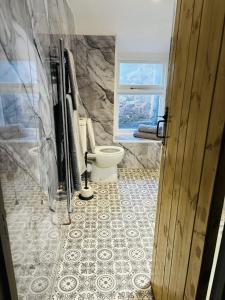 a bathroom with a toilet and a stone wall at Above the Bear in Taunton +9 photos