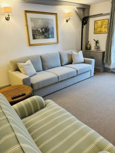 a living room with a blue couch and a table at Above the Bear in Wiveliscombe +9 photos