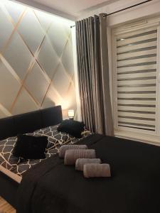 a bedroom with a black bed with two towels on it at Apartamenty Bartoszyce 2 in Bartoszyce