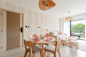 a dining room and living room with a table and chairs at Prado Suites Las Terrenas in Las Terrenas