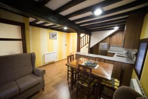 een woonkamer met een tafel en een keuken bij Casa Rural LA REGADERA I in Candelario