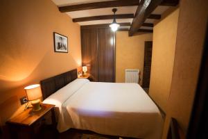 een slaapkamer met een groot wit bed en twee tafels bij Casa Rural LA REGADERA I in Candelario