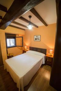 een slaapkamer met een groot wit bed en twee tafels bij Casa Rural LA REGADERA I in Candelario