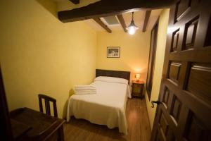 een slaapkamer met een bed en een tafel met een lamp bij Casa Rural LA REGADERA I in Candelario +8 foto's