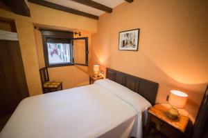 een slaapkamer met een wit bed en een raam bij Casa Rural LA REGADERA I in Candelario