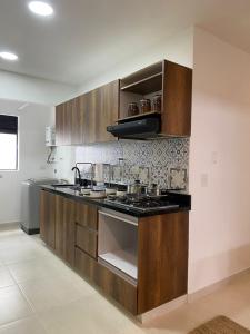 a kitchen with wooden cabinets and a stove top oven at Candilejas in Fredonia