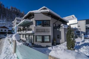 ゼルデンにあるApart Reinstadlerの建物の前に雪が積もっている