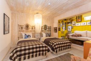 a bedroom with two beds and a couch in it at Casa da Almoinha in Unhais da Serra