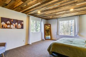 a bedroom with a bed and two windows at Quiet Alma Home with Deck - 20 Mi to Breckenridge! in Alma