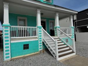 a blue house with a white staircase on it at Vibes Villa in Wildwood
