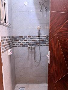 a shower with a glass door in a bathroom at CHS Vacation Stays Limited in Kampala