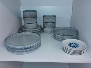 a group of plates and bowls sitting on a shelf at Naledi Holiday Apartment in Durban
