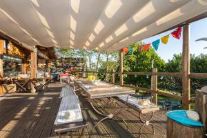 a patio with a table and benches on a deck at Casa da Almoinha in Unhais da Serra