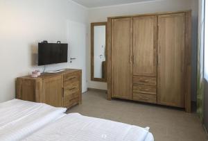 a bedroom with a bed and a tv on a wooden cabinet at DUENENZEIT App Nr 5 max 4 Pers in Dierhagen +2 photos