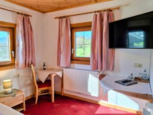 a room with a small table and a television at Lampererhof in Sankt Johann in Tirol
