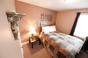 a bedroom with a bed and a lamp and a window at Misty Retreat in Niagara Falls