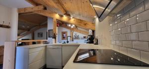 a kitchen with white appliances and wooden ceilings at Chalet Mugnier in Samoëns