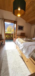 a bedroom with a bed and a large window at Chalet Mugnier in Samoëns