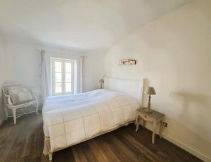 ein weißes Schlafzimmer mit einem Bett und einem Fenster in der Unterkunft HORIZON grande maison de charme à La Couarde in La Couarde-sur-Mer