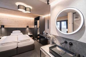ゼルデンにあるApart Reinstadlerのベッドと洗面台と鏡のある寝室 +23枚の写真