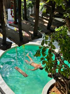 a man in a swimming pool with a swing at Chii Lú Casa de la Luna in Brisas de Zicatela