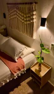 a bedroom with a bed and a table with a plant at Nabani in Brisas de Zicatela