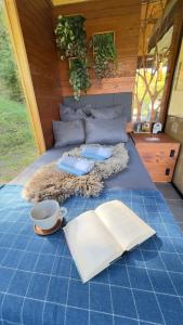a bed with an open book and an open book at Cosy getaway in raw nature in Šentjur