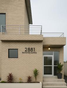 a brick building with a sign that readsresidents suites at Tris Estates Hotel & Suites in Dwarzohn