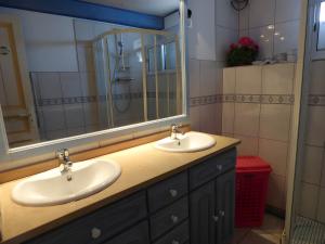een badkamer met twee wastafels en een grote spiegel bij Gite Chez Balum - 1 proche Lourdes in Lézignan +9 foto's
