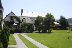 een huis met een groen gazon en een pad bij Gite Chez Balum - 1 proche Lourdes in Lézignan