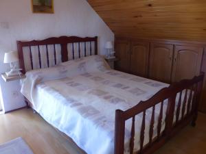 een groot houten bed in een slaapkamer met houten vloeren bij Gite Chez Balum - 1 proche Lourdes in Lézignan