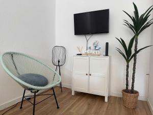 Cette chambre dispose d'une chaise et d'une télévision murale. dans l'établissement Stunning one bedroom apartment in the heart of Praia da Rocha, à Praia da Rocha