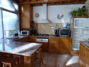 een keuken met houten kasten en een aanrechtblad bij Gite Chez Balum - 2 Proche Lourdes in Lézignan