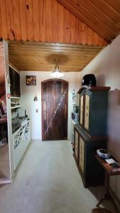 Zimmer mit einer Küche und einer Holztür in der Unterkunft Tranquility and Nature - 8 minutes from downtown Capivari in Campos do Jordão + 21 Fotos