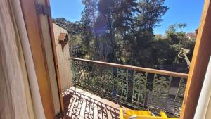 einen Balkon mit Blick auf einen Baum in der Unterkunft Tranquility and Nature - 8 minutes from downtown Capivari in Campos do Jordão
