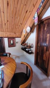 ein Esszimmer mit einem Tisch und einer Uhr an der Wand in der Unterkunft Tranquility and Nature - 8 minutes from downtown Capivari in Campos do Jordão